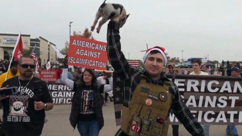 أمريكي يضع نسخة من القرآن الكريم في فم خنزير خلال احتجاج مناهض للإسلام في تكساس (فيديو)